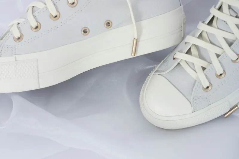 Zapatillas blancas de lona sobre una tela blanca: servicio de lavado de zapatillas